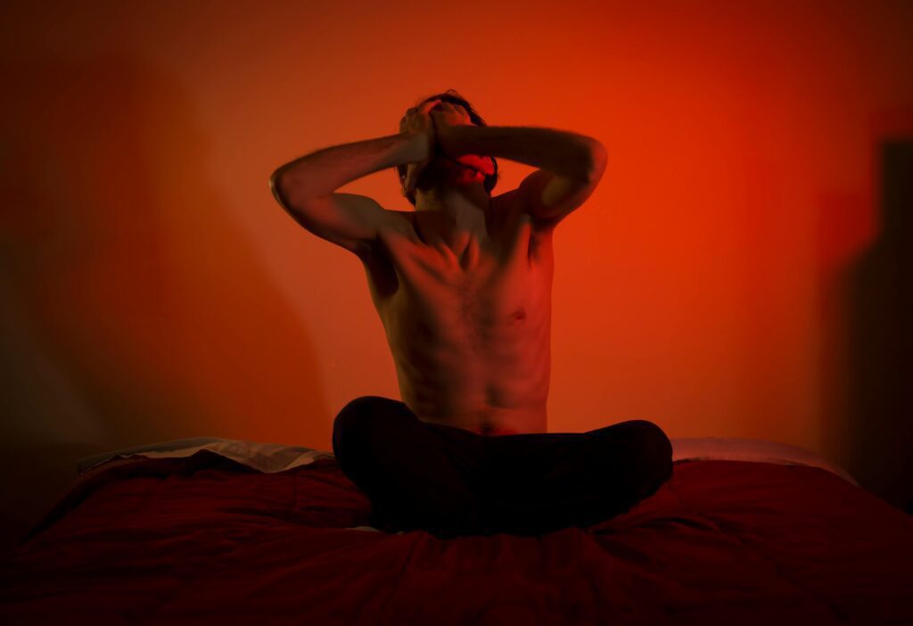 Topless Man Sitting on the Bed