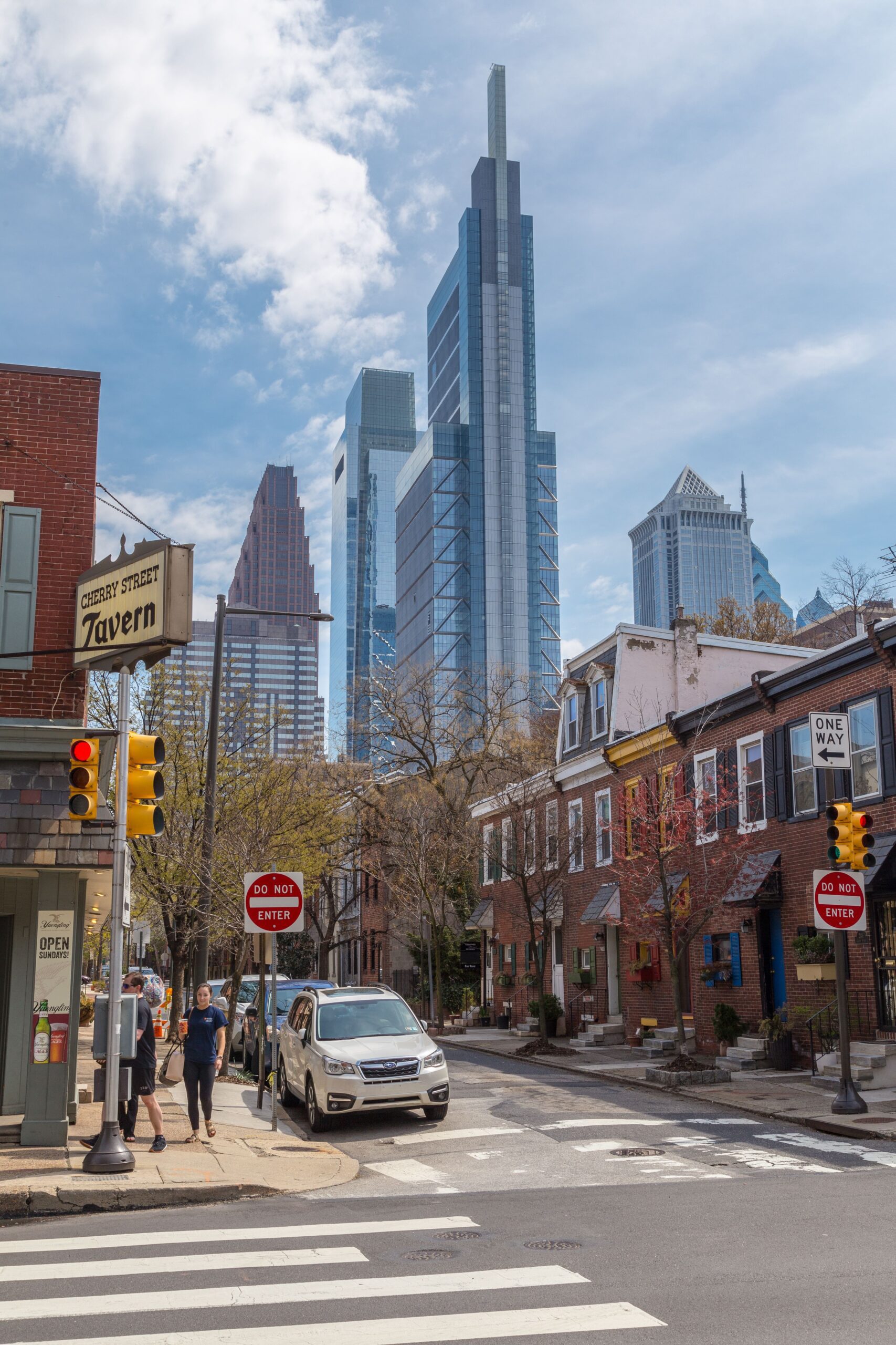 A vibrant street view in Philadelphia showcasing modern skyscrapers against a blue sky.