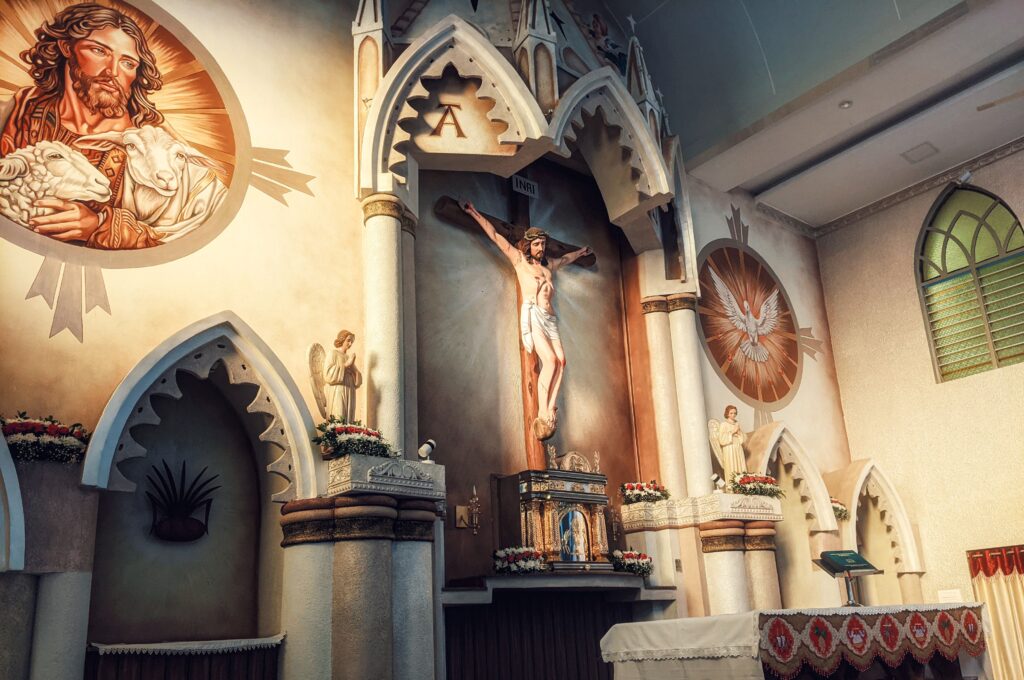 A detailed view of a church altar featuring a crucifix and religious icons in a serene indoor setting.