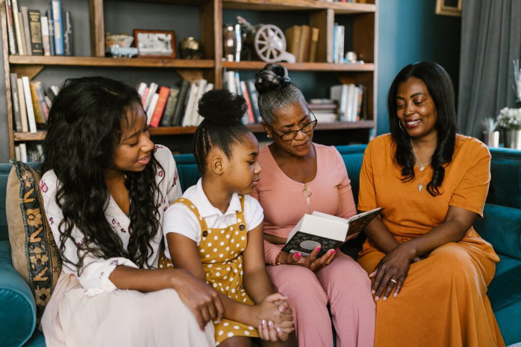 pexels-photo-7951621-7951621 A multigenerational family enjoys reading at home, sharing smiles and togetherness.