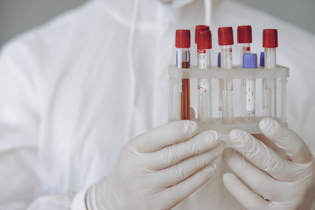 pexels-photo-4149031-4149031 Scientist in protective gear holding test tubes in a lab setting.