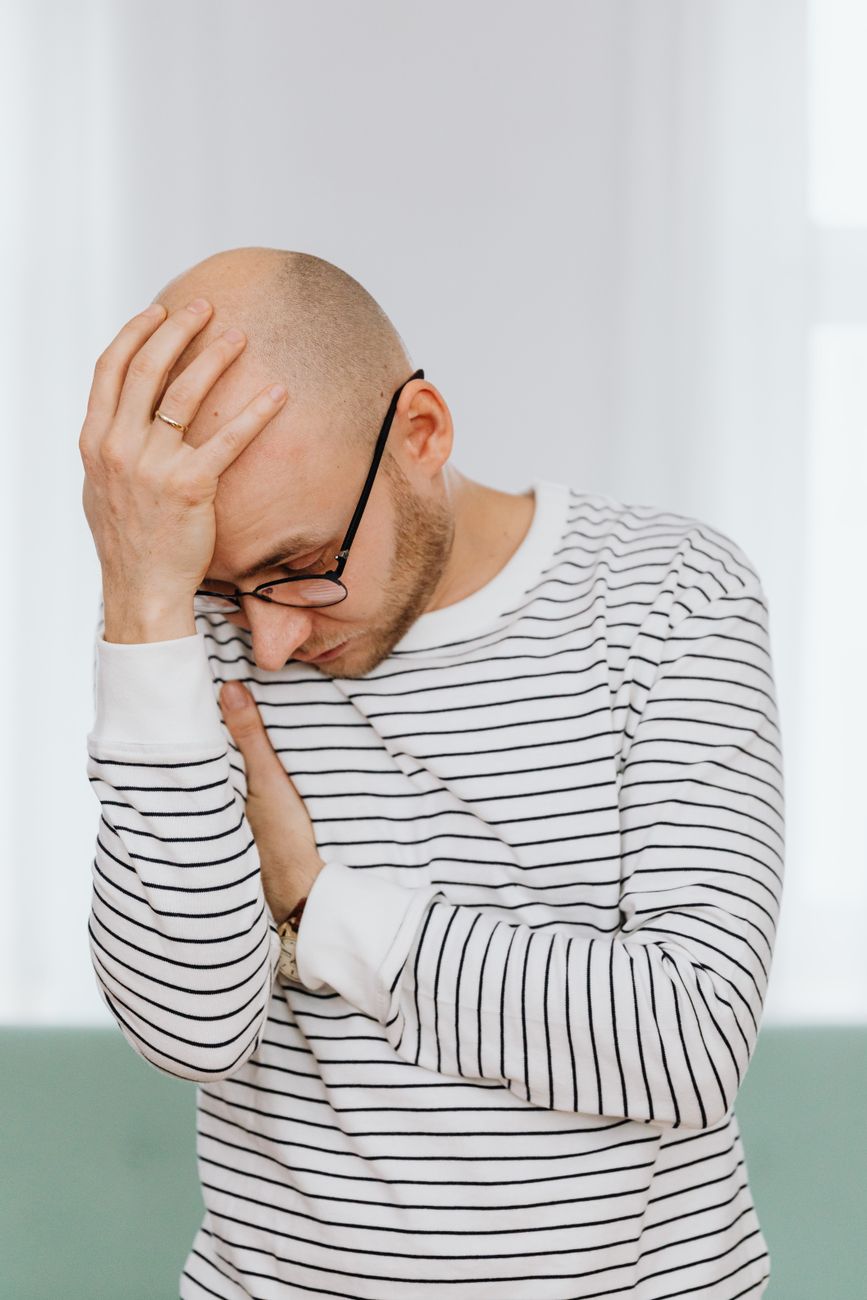 man with hand on head