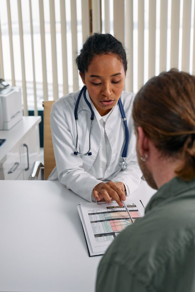pexels-photo-7578797-7578797 Female doctor discusses health chart with patient during consultation in office setting.